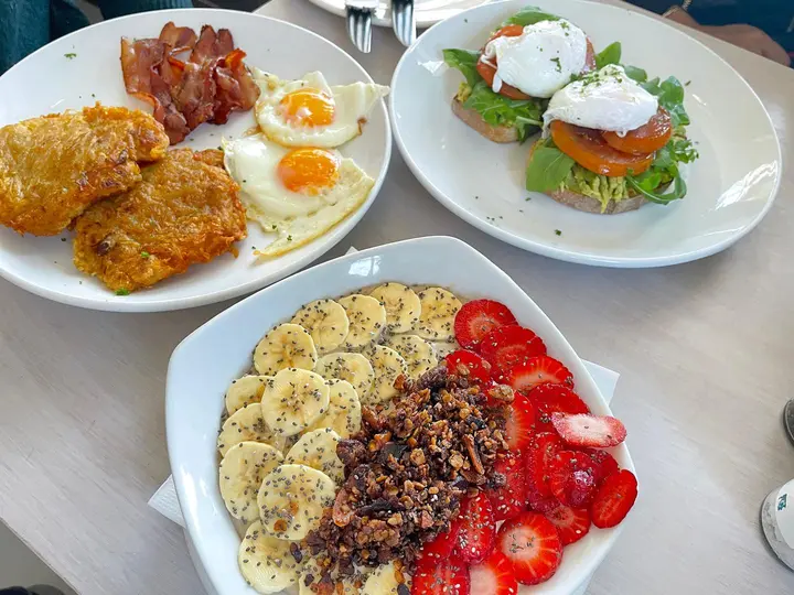Breakfast plates: eggs with rösti and bacon, poached eggs on toast, and a granola bowl with fruit